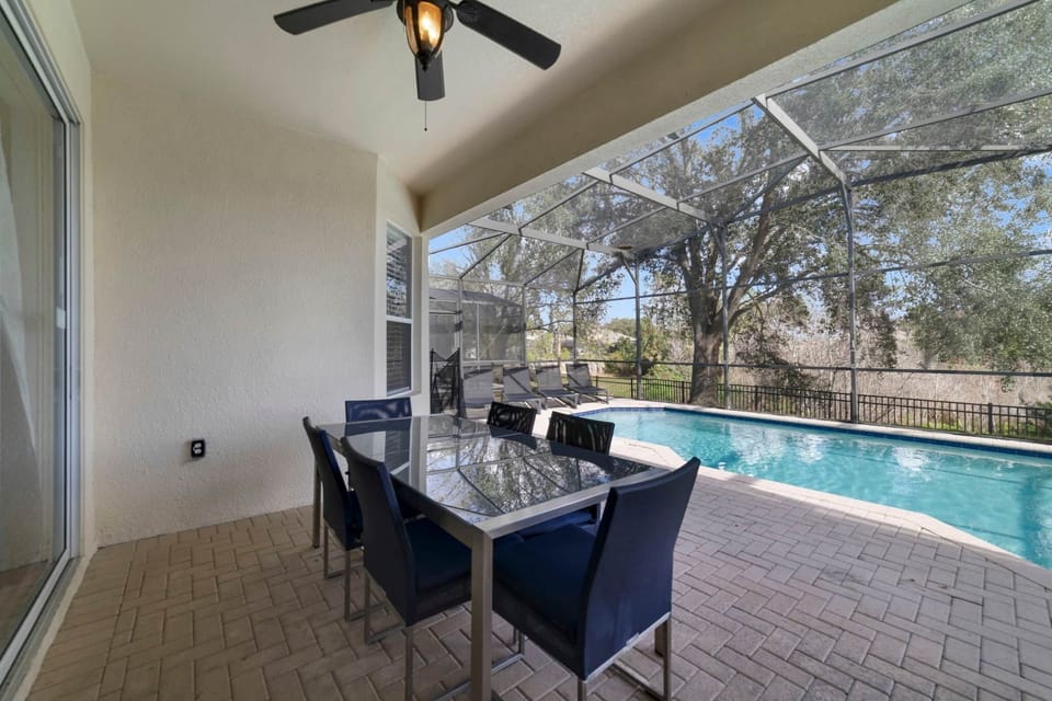Outdoor dining and pool with four lounge chairs and a hot tub.