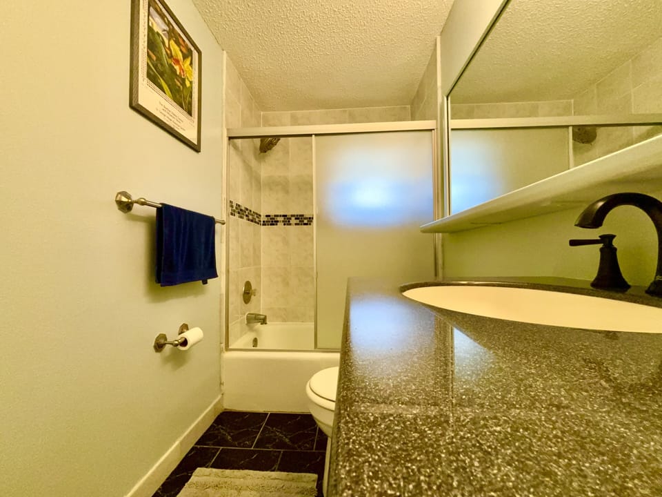 Guest bathroom with window and louvered door to keep the wind blowing.
