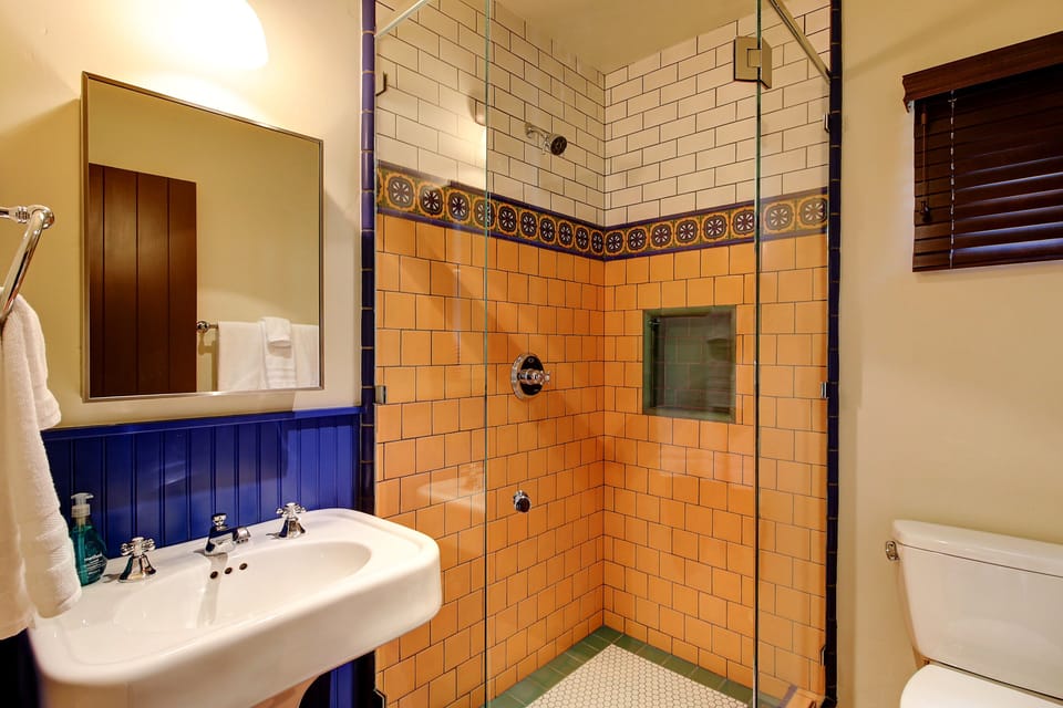 Guest bathroom offers the same exquisite Spanish tile including a shower with lots of sustainable guest amenities.