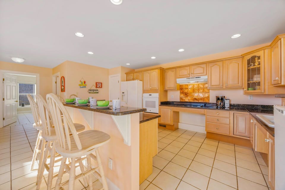 Your spacious kitchen welcomes you with warm wood cabinets, granite counters, and a breakfast bar perfect for morning coffee or casual meals.