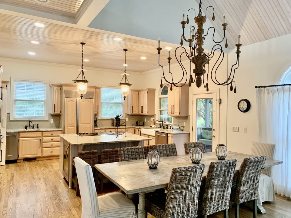 Large open kitchen, dining, living area with seating for 8 people at table.
