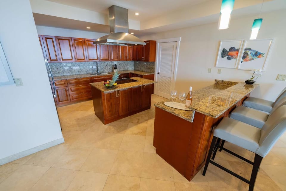 Granite countertops extend across the kitchen island and breakfast bar, paired with cherry wood cabinetry.