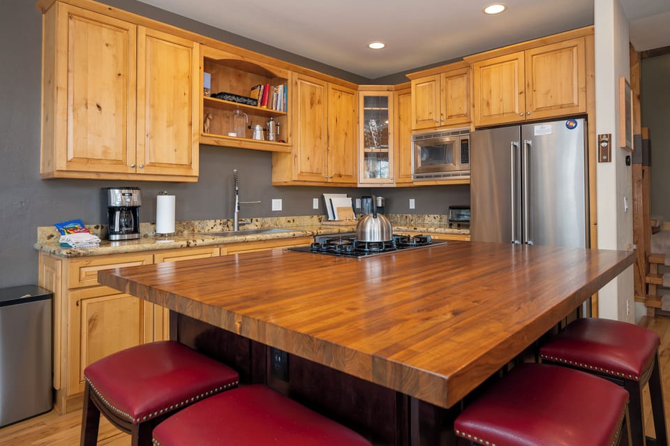Your fully equipped kitchen features warm wood cabinetry, granite counters, and a spacious island where you can gather for meals or morning coffee.