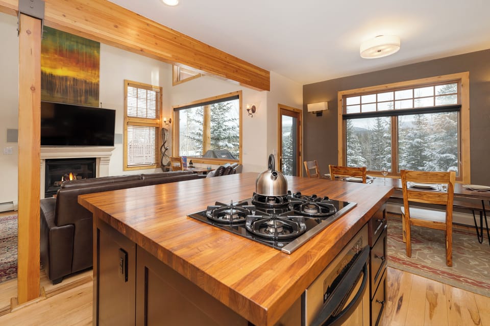 Cook memorable meals in this stunning kitchen with butcher-block island while enjoying mountain views through expansive windows.