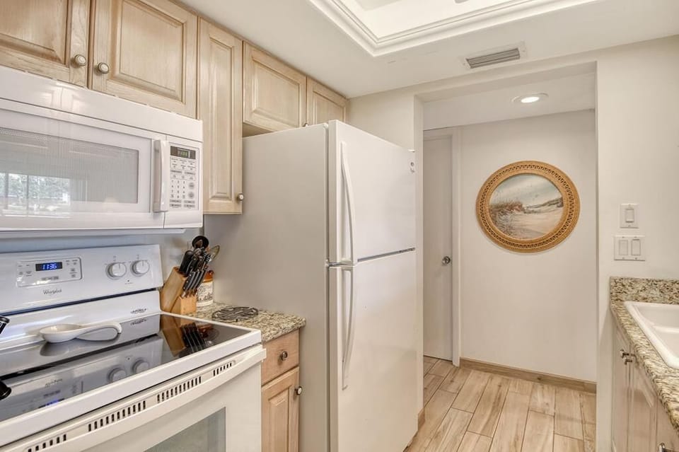 Galley kitchen with white appliances