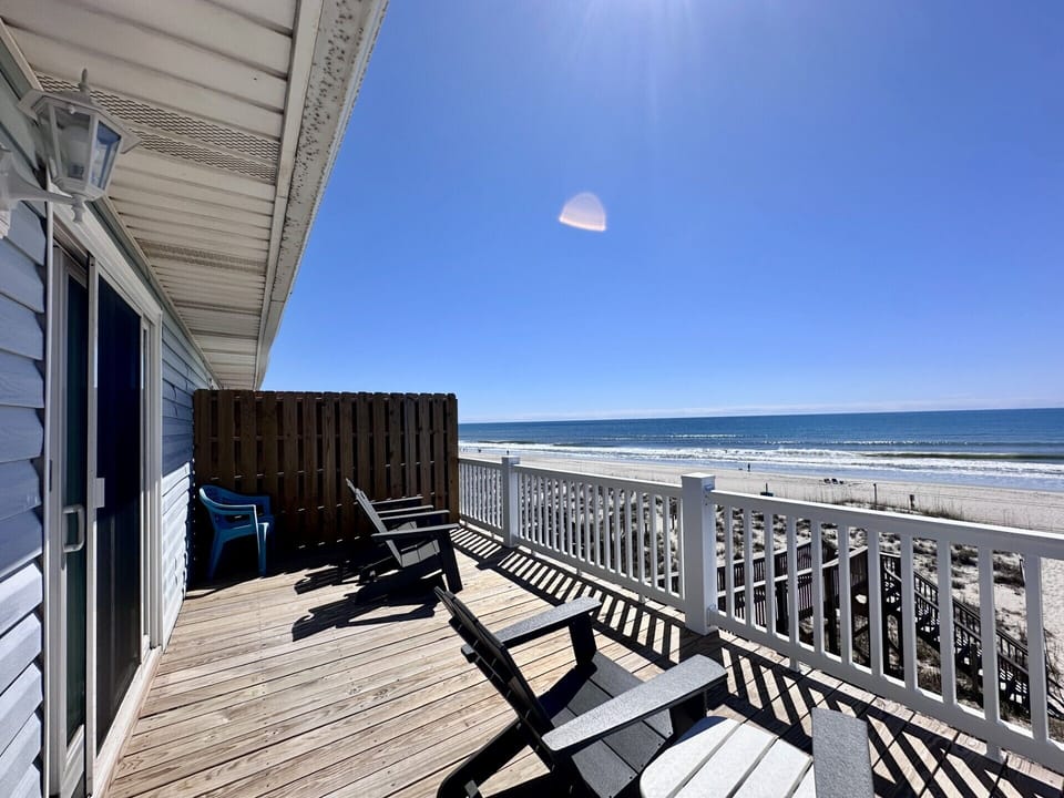 Your private oceanfront deck offers front-row seats to endless waves and soft sand, with comfortable chairs perfect for morning coffee or sunset relaxation.