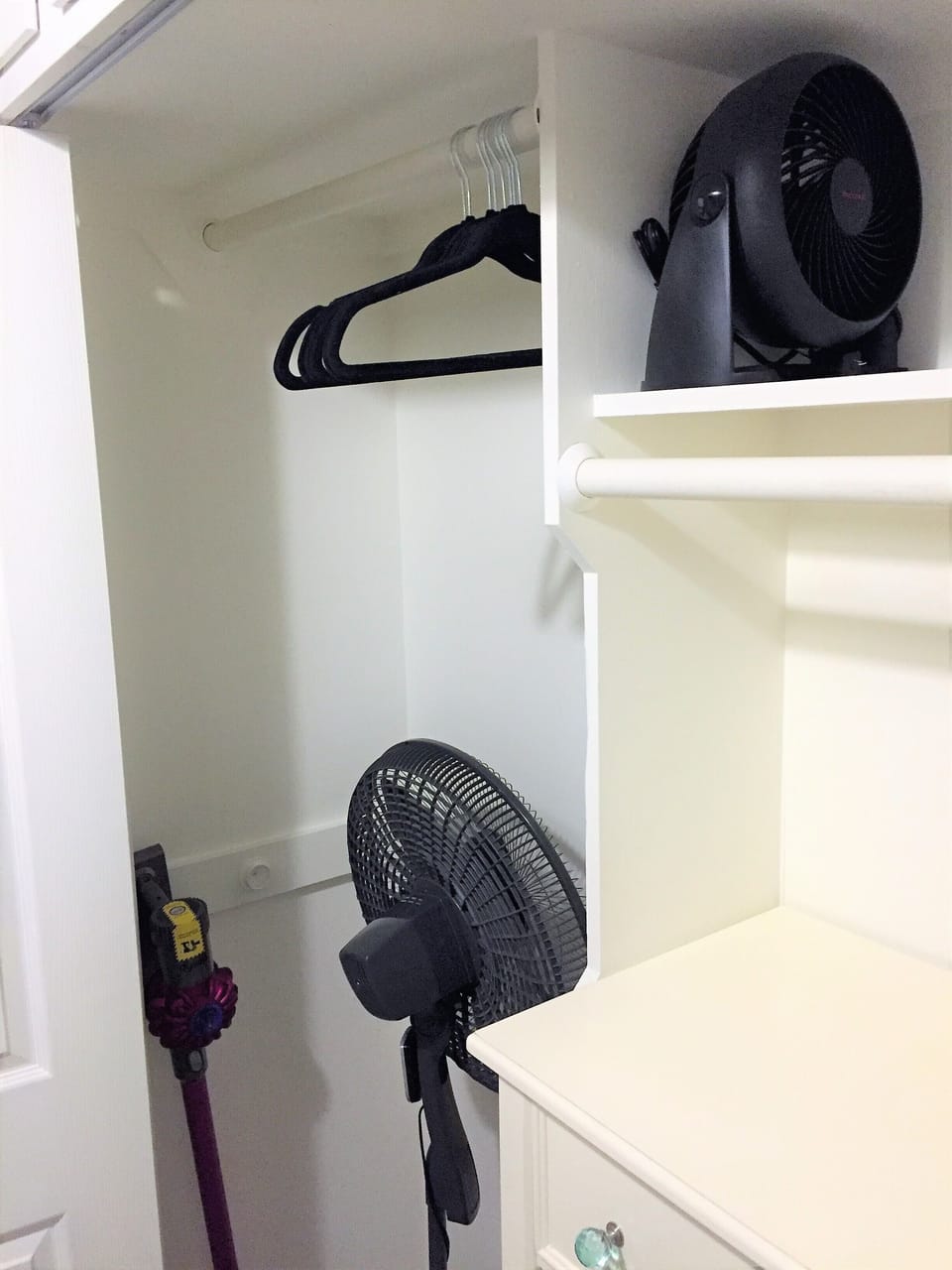 Twins bedroom closet with dresser, hangers and fans.