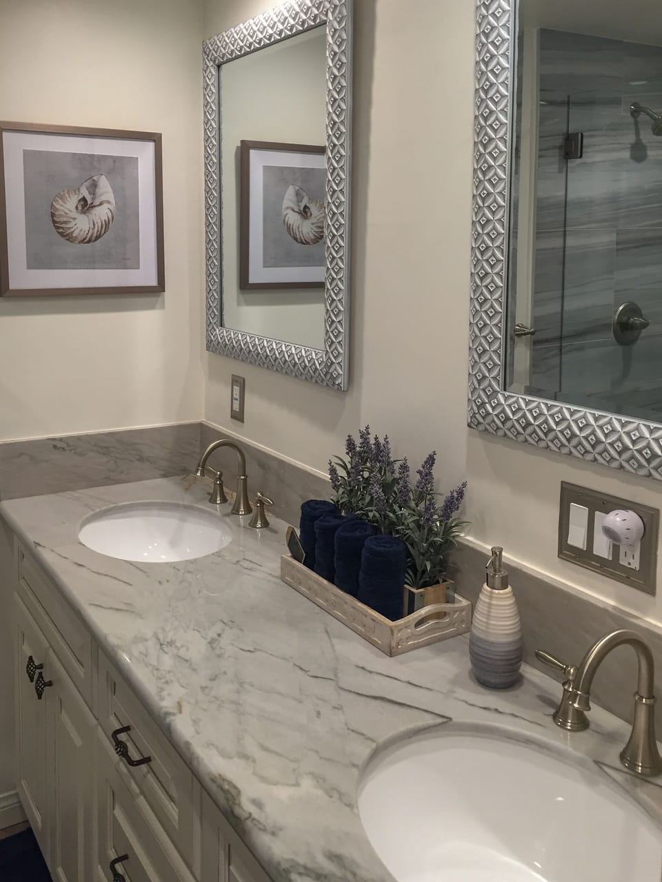 Bathroom w/ dual granite top sinks.  Hair dryer and first aid kit stored below.