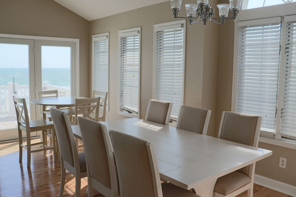 Gather around this spacious dining table where your group can share memorable meals while enjoying natural light streaming through multiple windows.