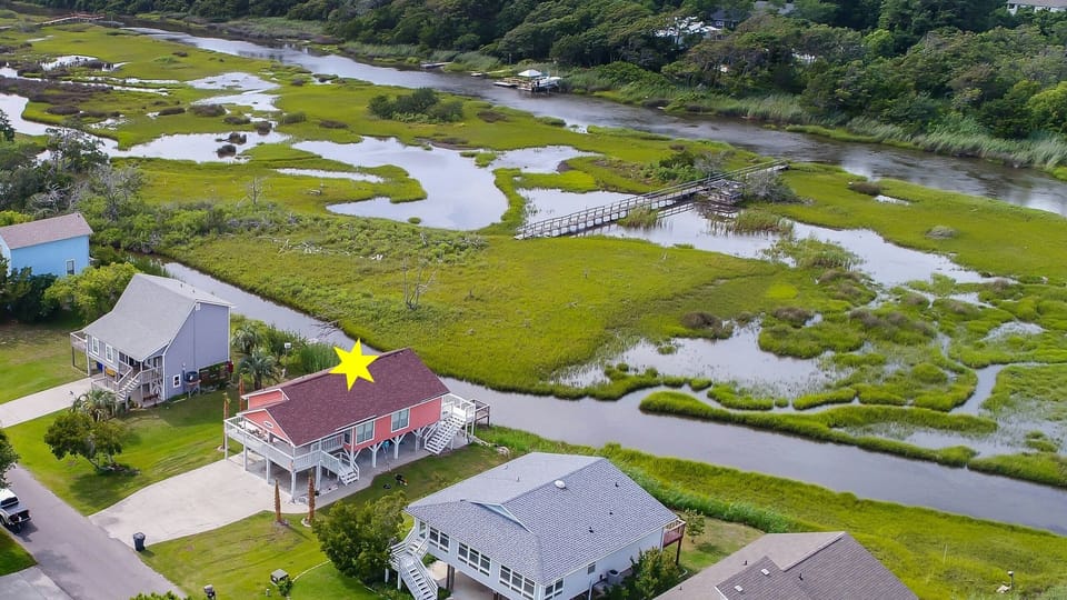 Aerial view of house, canal, and marsh