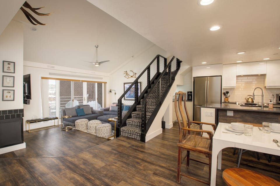 Modern staircase with sleek railings guides you to your upstairs retreat, while Colorado ski artwork adds mountain charm to your stay.