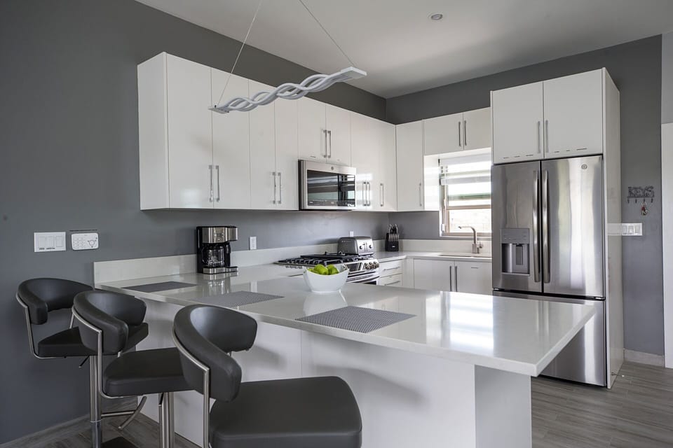 Kitchen with Blender, Microwave, Fridge, Gas Stove, Toaster, Coffee Maker.