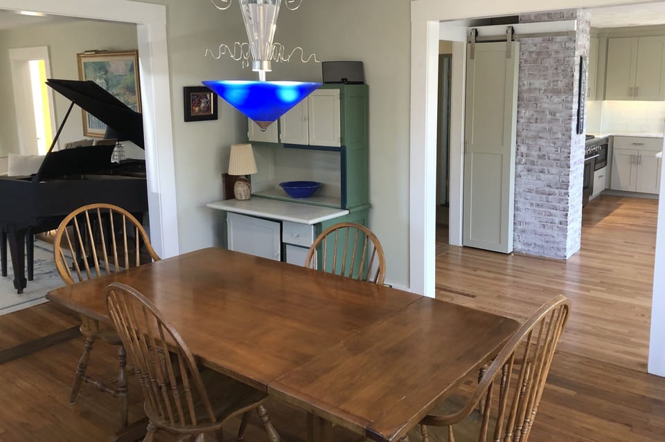 Enjoy extra storage in the antique Hoosier  cabinet & shelves behind barn door. 