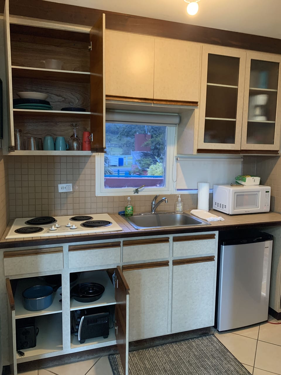 equipped kitchen with utensils, plates, pans