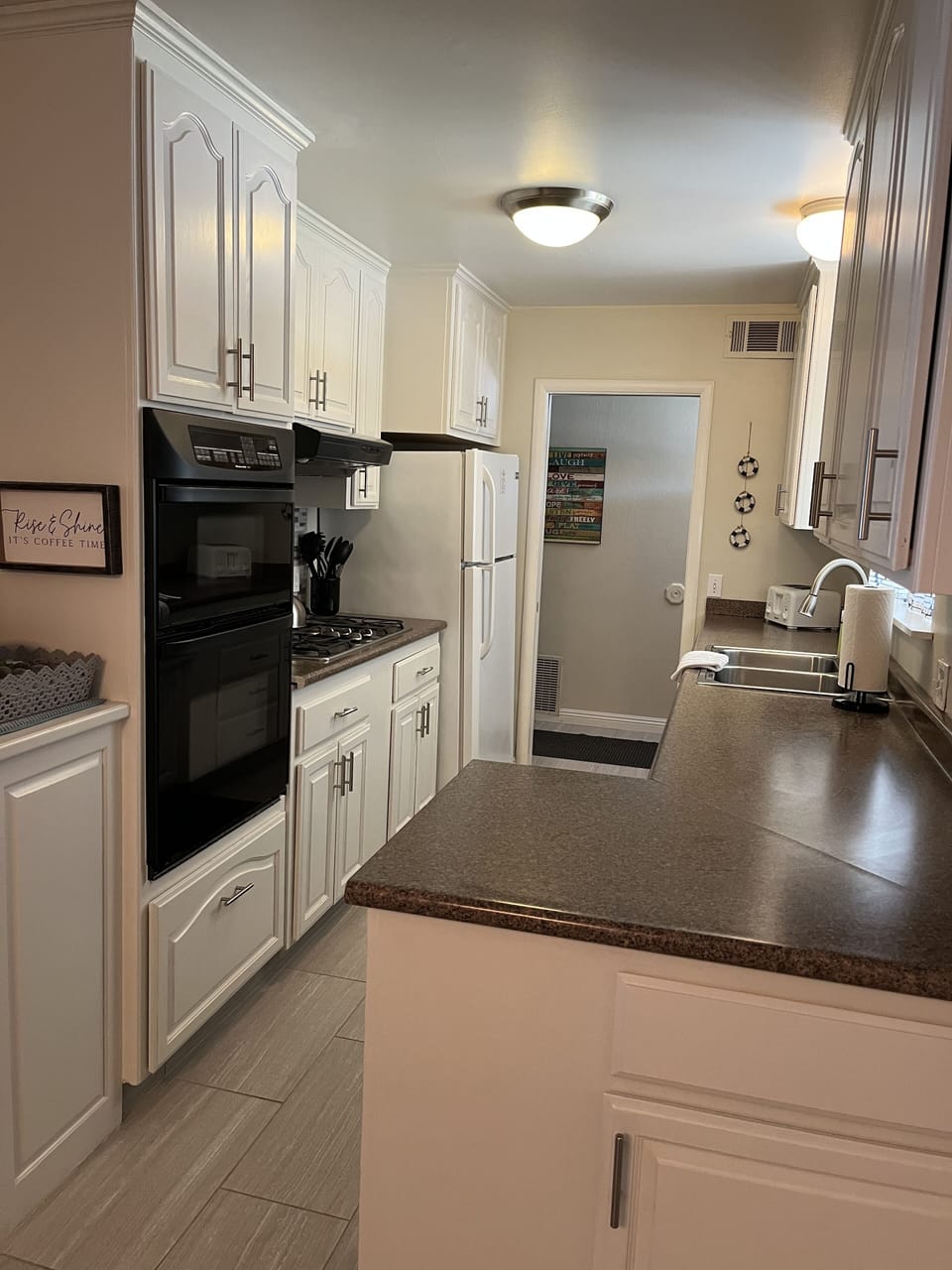 Galley kitchen flows to homes entry and dining table and family room...