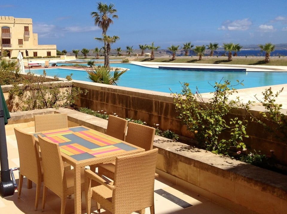Outdoor furniture in private terrace with views of pool and Mediterranean Sea