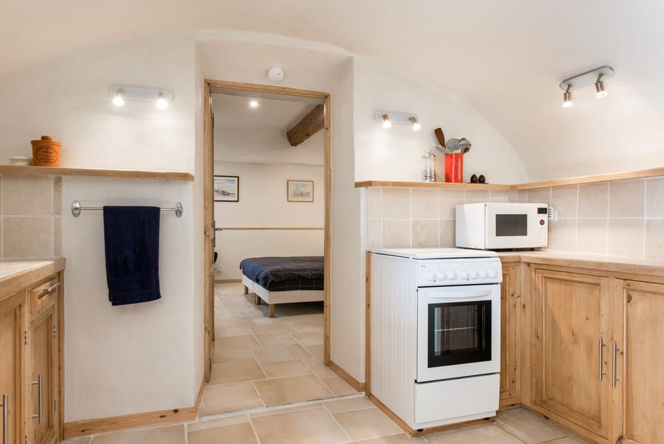 Gites Marston: La Petite Grange - Open plan kitchen & entrance to lower bedroom