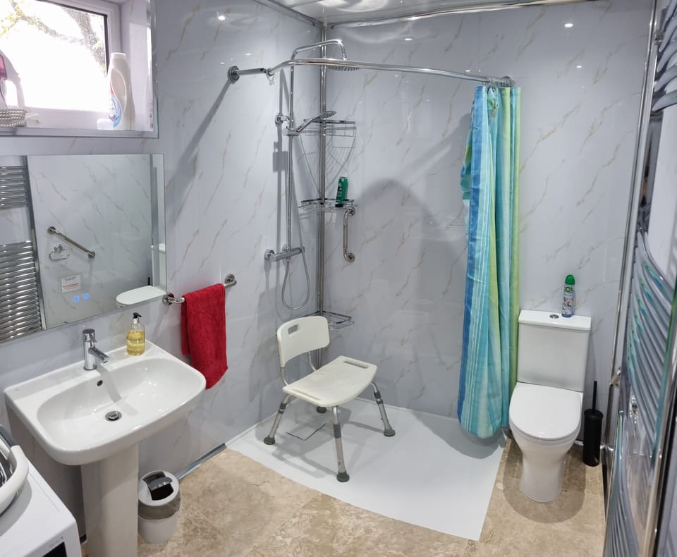 Step-free accessible bathroom, fitted with grab-rails and shower chair.