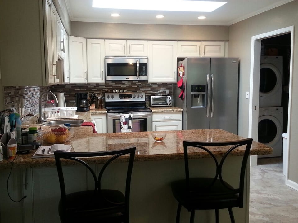 Full on View of Kitchen with Bar Seating and Laundry
