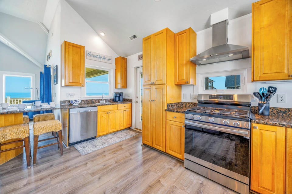 Your gourmet kitchen with ocean views invites you to cook with coastal inspiration—granite counters, stainless appliances, and bright windows bring the seaside indoors while you create memorable meals in this sunlit culinary haven.