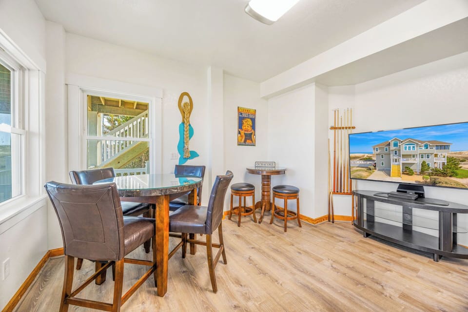 Gather around the dining table for meals and game nights, then relax in your bright, open living space with coastal decor and entertainment ready for your beach vacation.