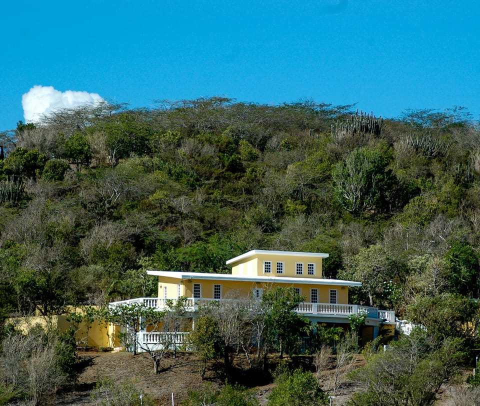View of our hillside home and part of the land from across the valley.