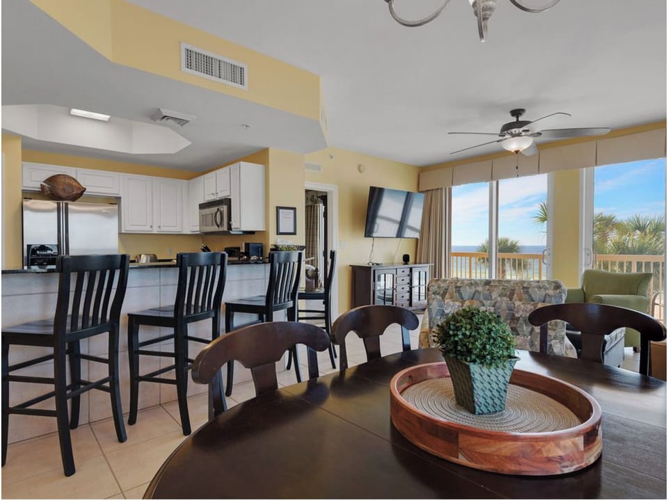 Your open-concept kitchen and dining area flows seamlessly to your living room, where ocean views through expansive windows create the perfect backdrop for memorable meals.