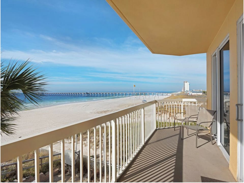 Expansive beachfront balcony offers stunning ocean views with white sand beach stretching endlessly beyond your private outdoor space.