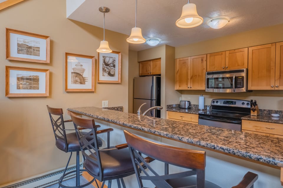 Beautiful slab granite bar with extra seating, 3 swivel leather bar stools! 