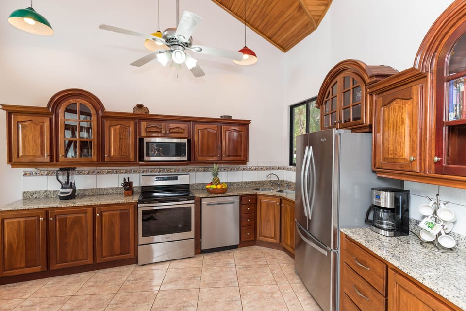 Kitchen includes stainless steel appliances, plenty of tableware and cookware