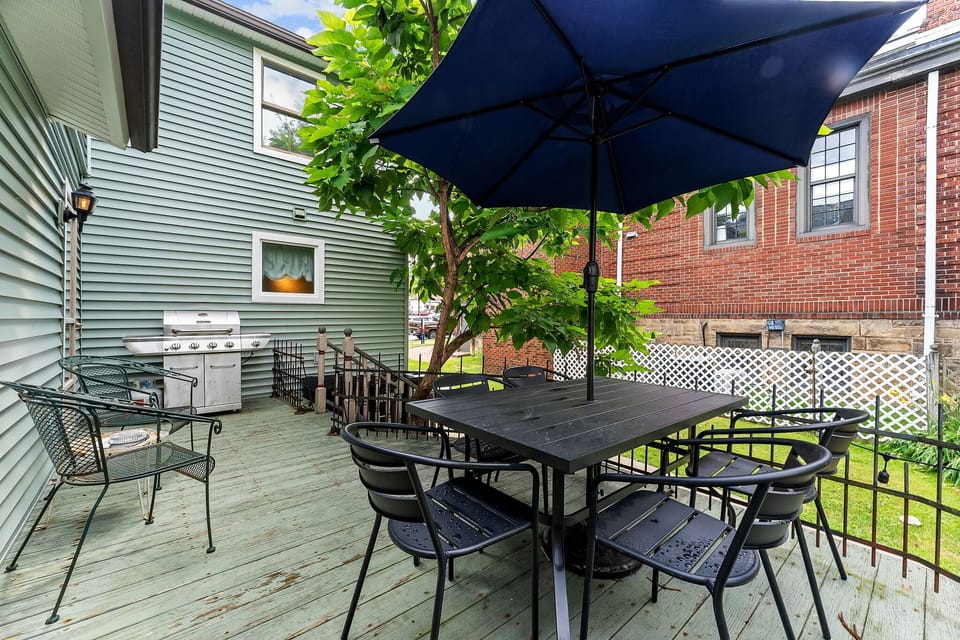 Outdoor table with umbrella and grill for easy cookouts.