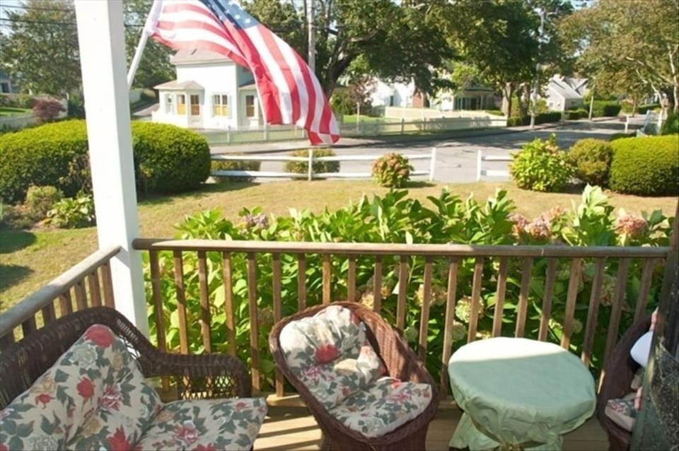 Private front porch with comfortable seating for socializing; large front yard.