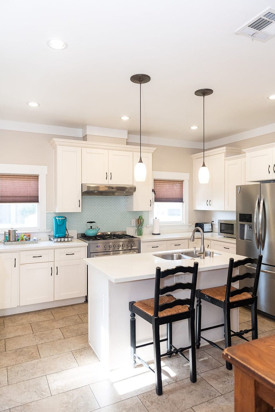 A beautiful and fully stocked kitchen with island, extra seating and 36" Cosco gas range.