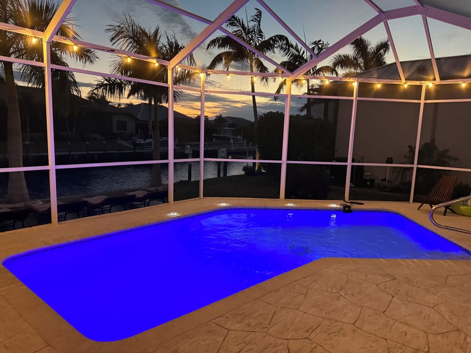 POOL GLOWS AT NIGHT WITH AMAZING VIEW OF PALM TREES