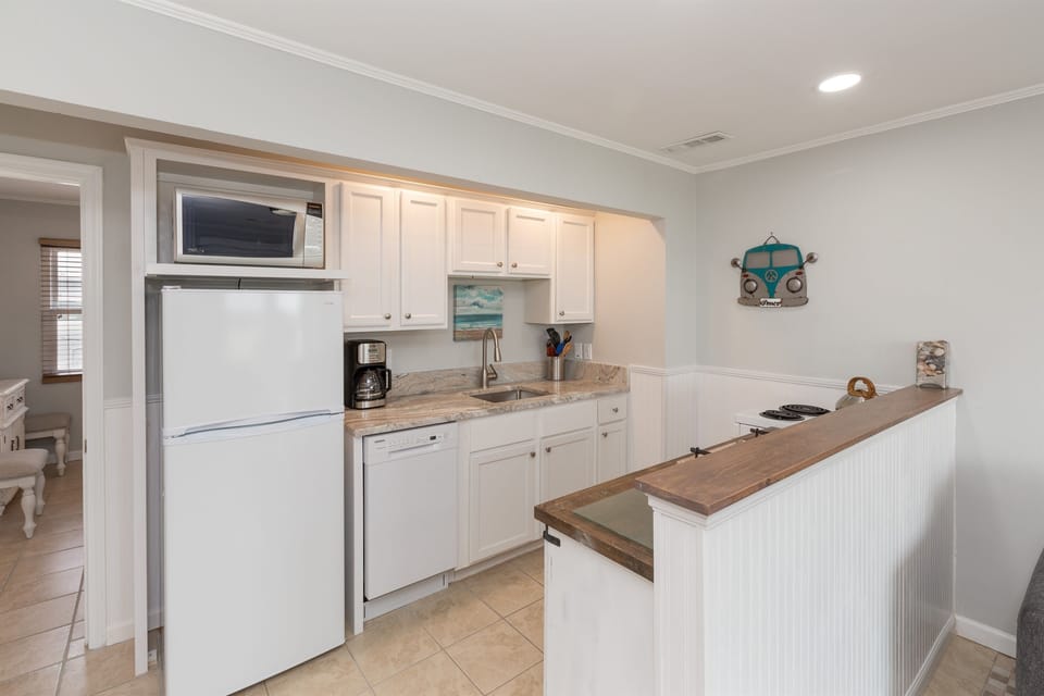 Built in appeal in this kitchen with all essentials including coffee maker, toaster, microwave, stove/oven, and enough pots pans and tools to eat in.