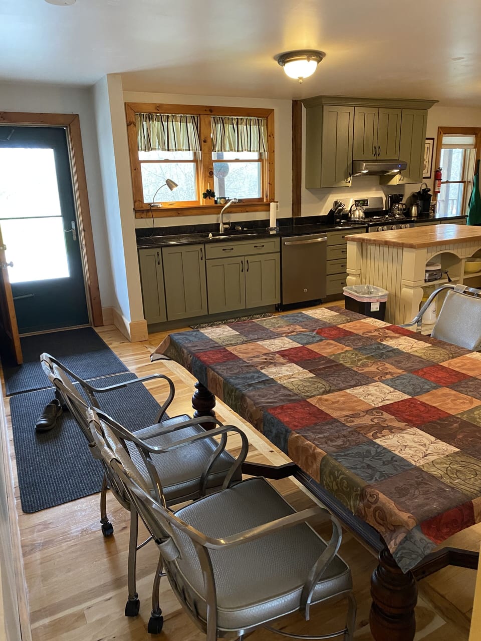 Looking over kitchen table to exterior door that goes out onto porch deck.