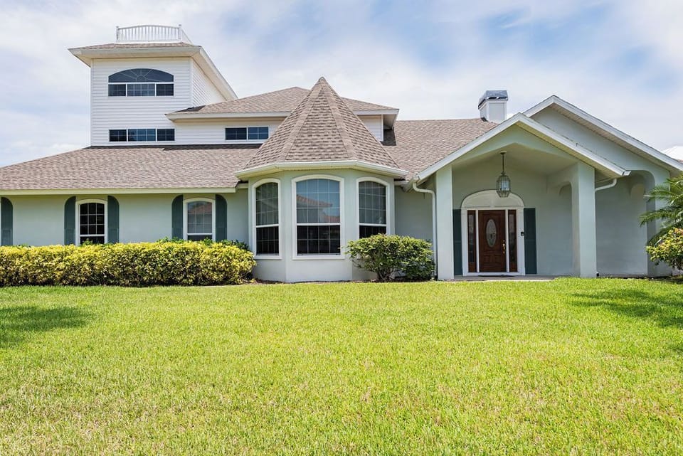 Front of home with large landscaped lot