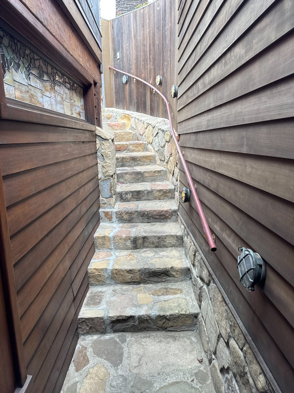 Uppermost stairwell leads up from the units to the top deck and parking lot. (railings on one side)