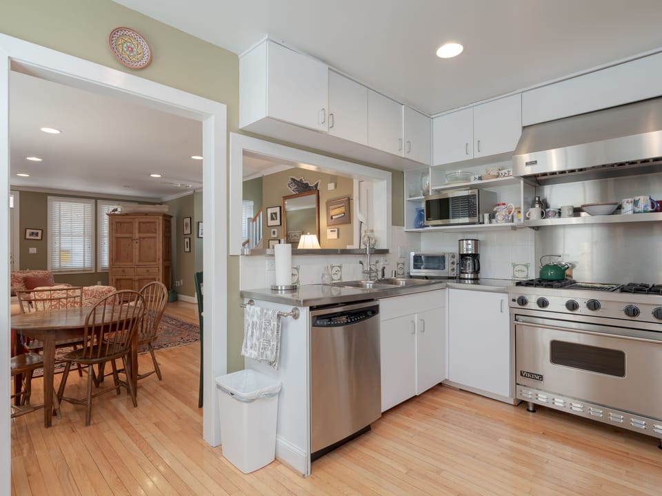 Stainless countertops and appliances combine with white cabinets