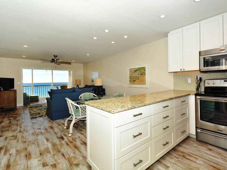Modern, renovated, fully equipped kitchen with granite counters, glass tile backs splash...