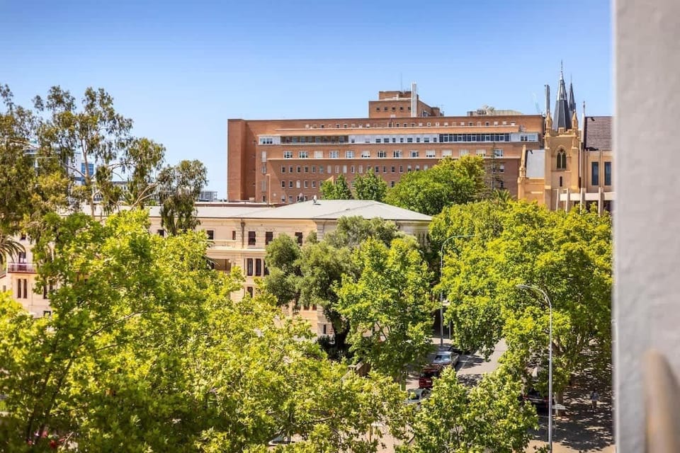 Peaceful urban view with lush greenery, historic architecture, and plenty of natural light perfect for relaxing or people-watching.