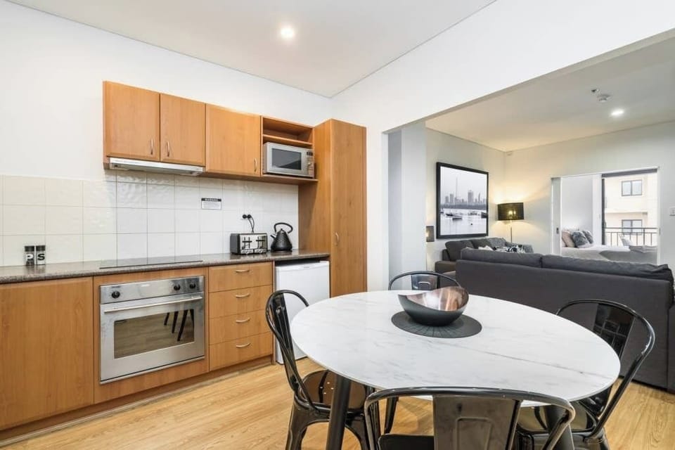 Modern open-plan kitchen and living area with sleek furnishings, perfect for a comfortable and stylish stay.