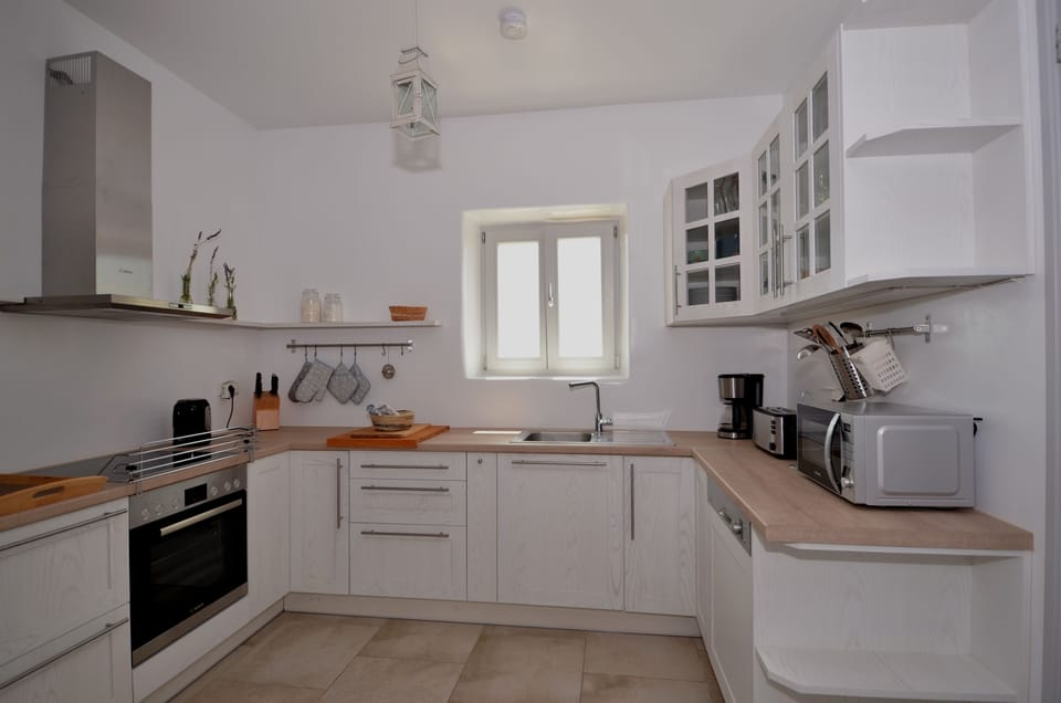 The open kitchen is fully equipped with household appliances.