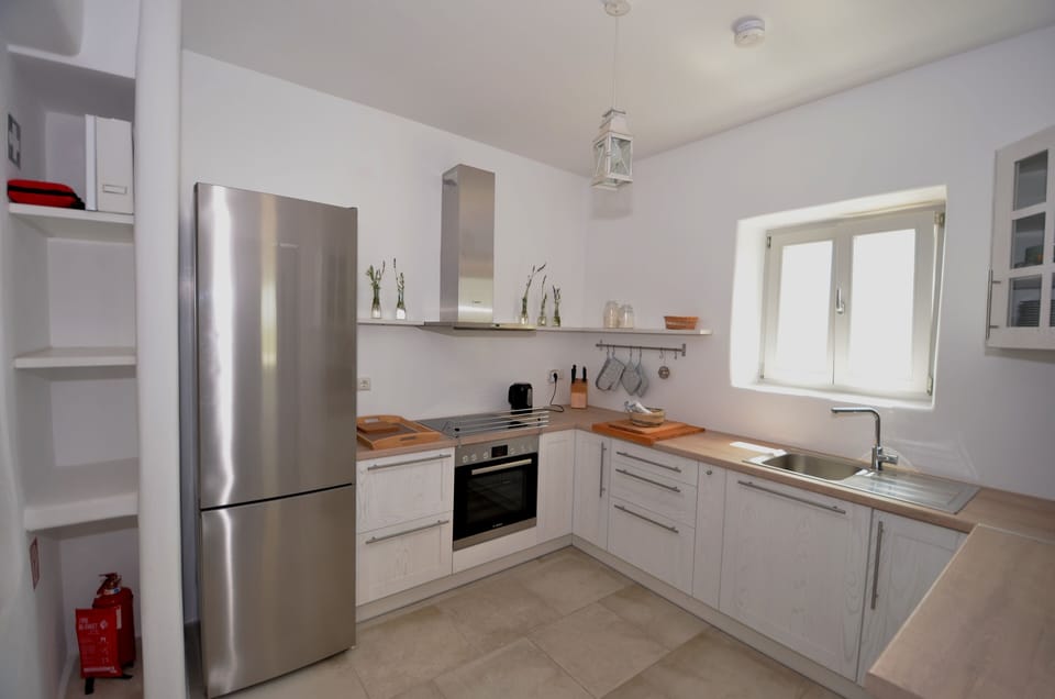 The open kitchen is fully equipped with household appliances.