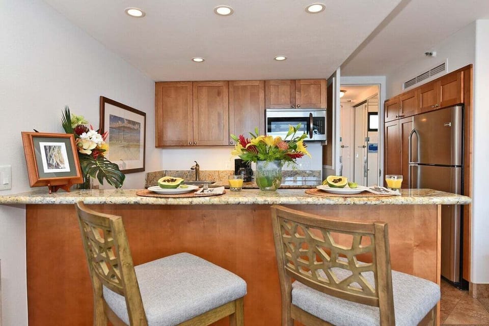 A warm, inviting kitchen with granite countertops, rich wood cabinetry, and a beautifully set bar perfect for casual island dining.