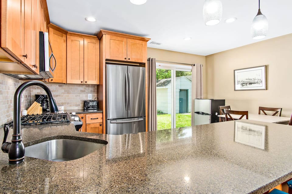 modern kitchen with stainless appliances and quartz counters