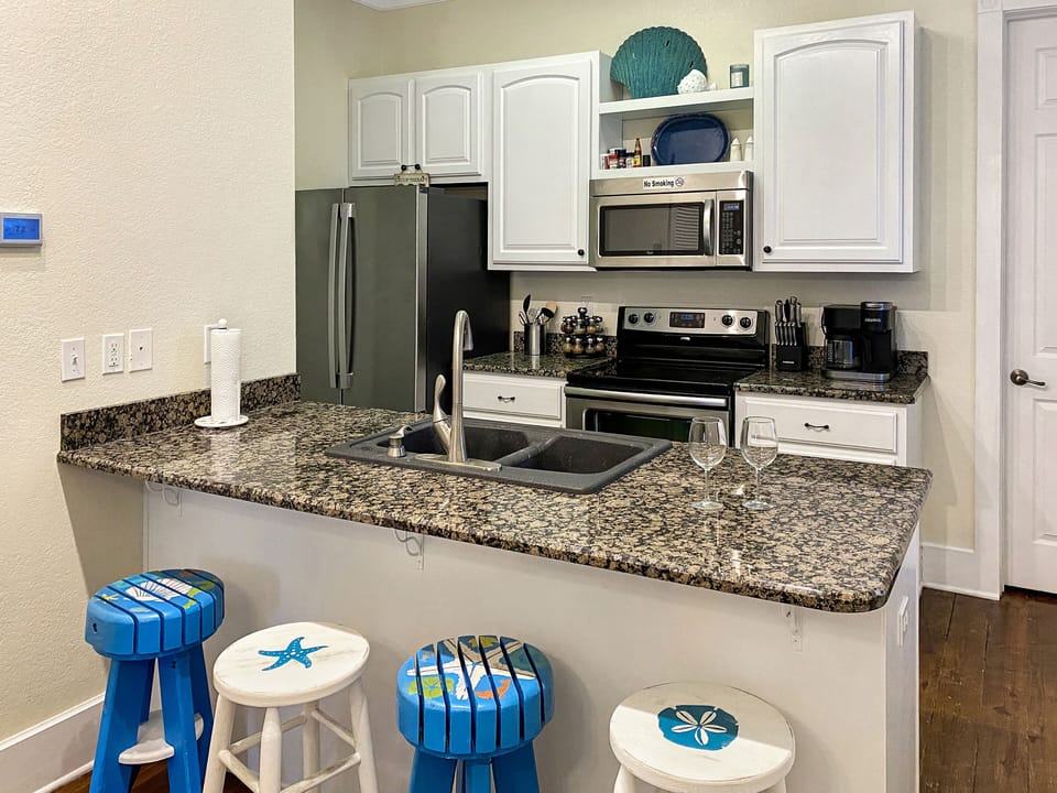 Kitchen with stainless steel appliances.  Full stocked with dishes and cookware.