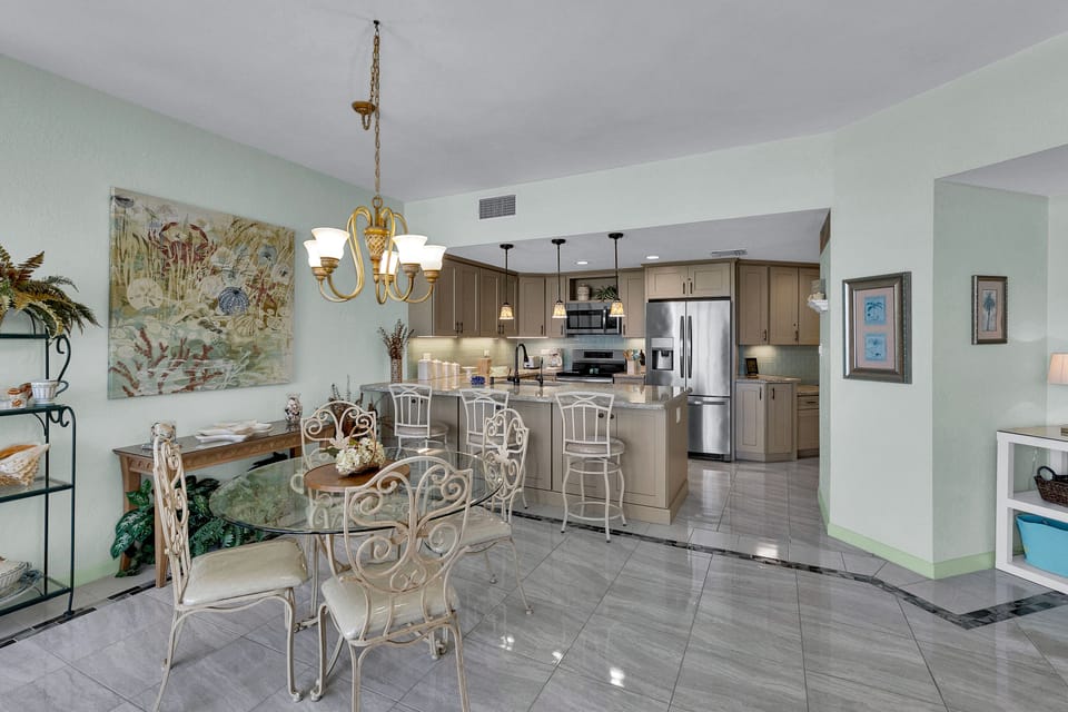 Kitchen  and dining areas with seating for 4 at the table and 3 at the bar
