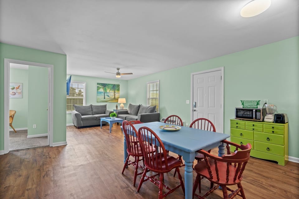 Relax in your cheerful open-plan space where mint green walls create a calming atmosphere for family meals and cozy evenings together.