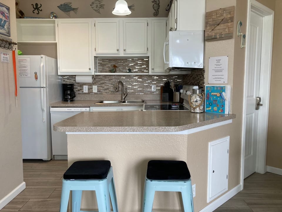 Updated kitchen with glass backsplash and under cabinet lighting.